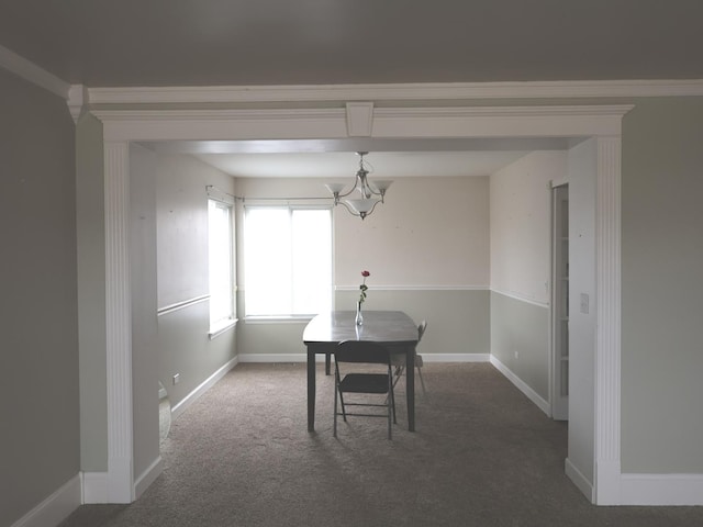 carpeted dining space featuring a chandelier