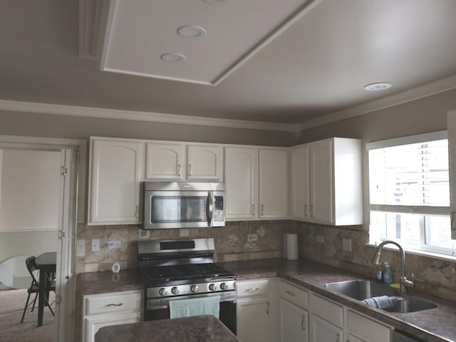 kitchen featuring sink, ornamental molding, white cabinets, and appliances with stainless steel finishes