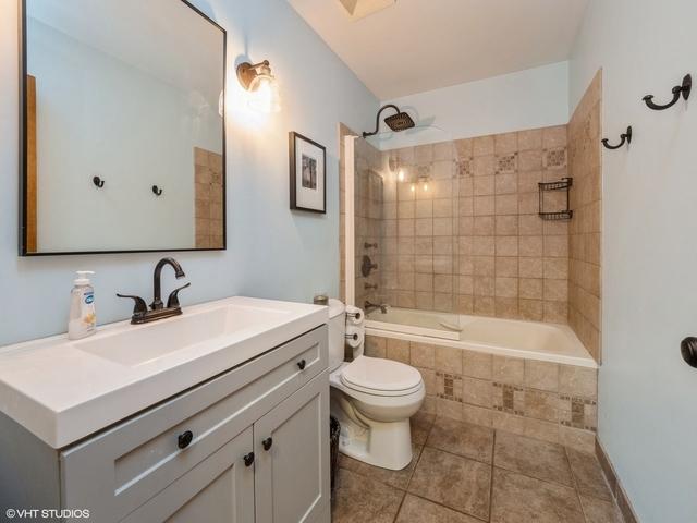 full bathroom with tile patterned floors, vanity, toilet, and tiled shower / bath combo