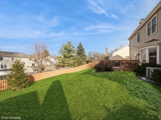 view of yard featuring a deck and central AC unit