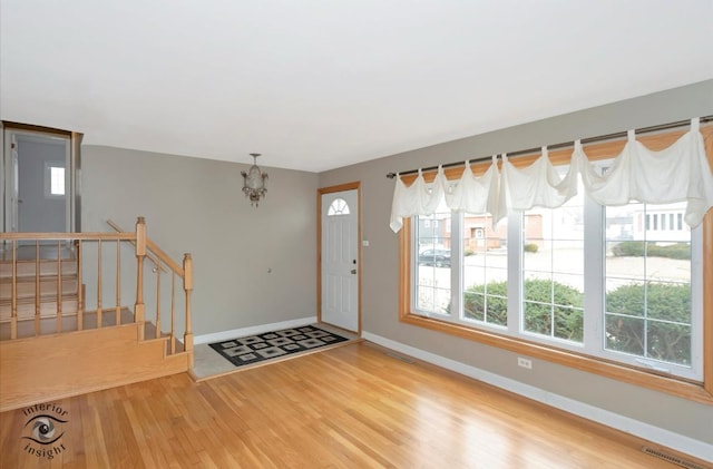 foyer entrance featuring hardwood / wood-style floors and a notable chandelier