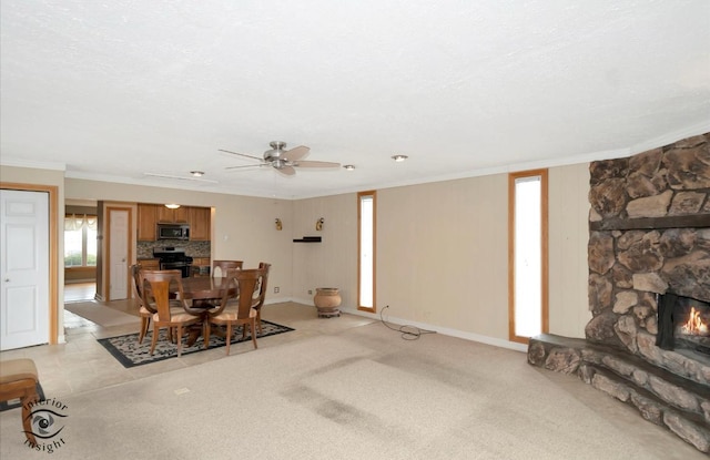 dining area with ornamental molding, a stone fireplace, light carpet, and a textured ceiling