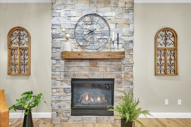 details featuring a fireplace, baseboards, and wood finished floors