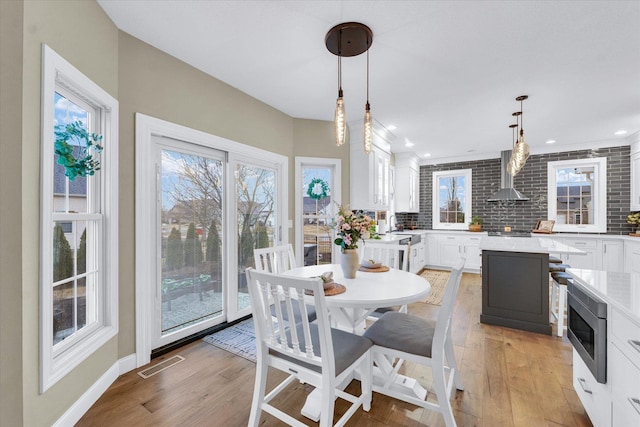 dining space with baseboards, recessed lighting, visible vents, and light wood-type flooring