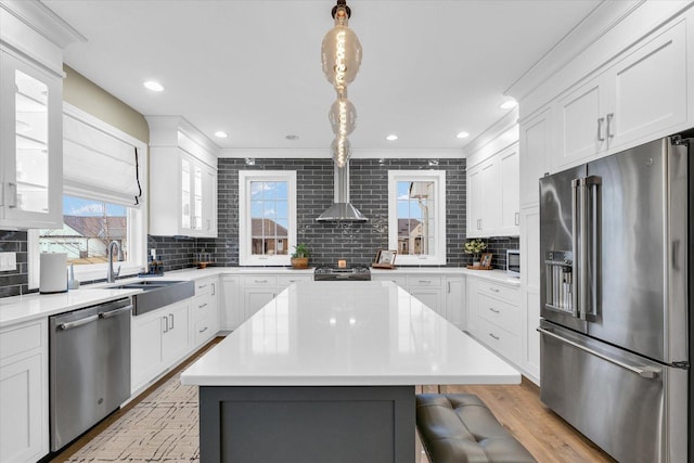 kitchen with white cabinets, backsplash, appliances with stainless steel finishes, and a sink