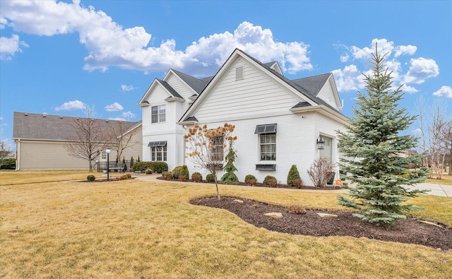 view of front facade with a front lawn and brick siding