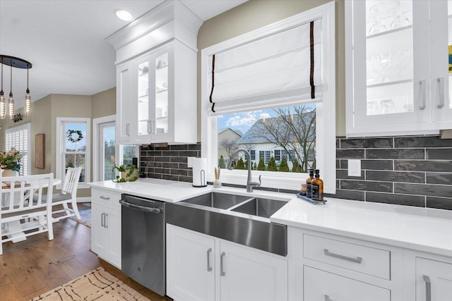 kitchen with a healthy amount of sunlight, dishwasher, light countertops, and a sink