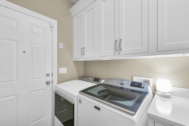 clothes washing area with cabinet space and washer and dryer