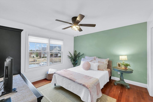 bedroom featuring ceiling fan, baseboards, and wood finished floors