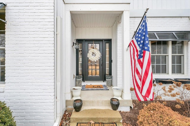 view of exterior entry featuring brick siding