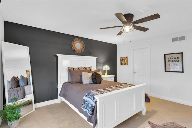 bedroom featuring visible vents, light colored carpet, a ceiling fan, and baseboards