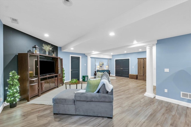 living area with recessed lighting, visible vents, light wood-style floors, and ornate columns