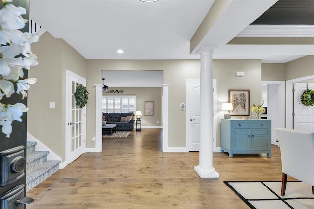 foyer entrance with light wood finished floors, recessed lighting, baseboards, and decorative columns