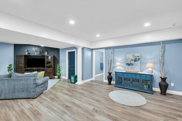 living room featuring recessed lighting, decorative columns, wood finished floors, and baseboards