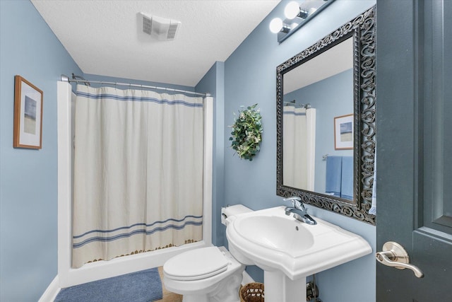 bathroom with visible vents, curtained shower, toilet, a textured ceiling, and a sink