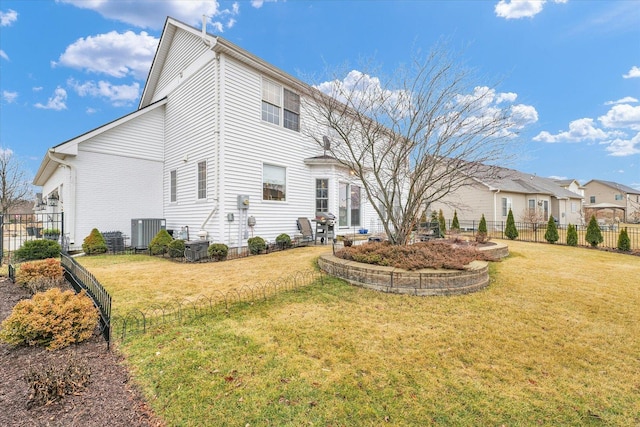 rear view of property featuring cooling unit, a yard, and fence