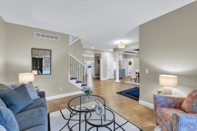 living area with light wood-type flooring, visible vents, recessed lighting, baseboards, and stairs