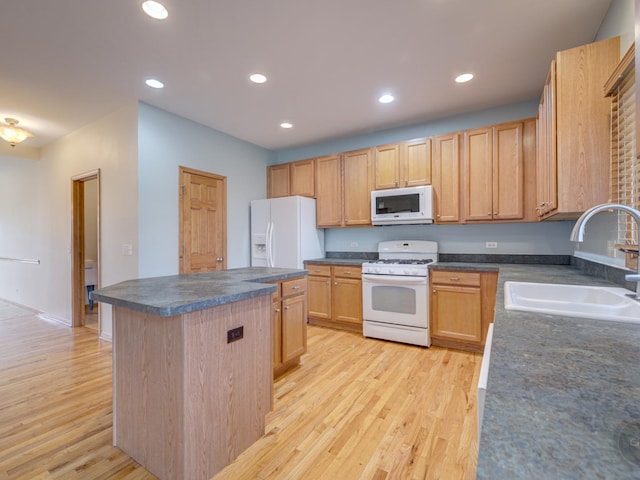 kitchen with a kitchen island, sink, light hardwood / wood-style floors, light brown cabinets, and white appliances