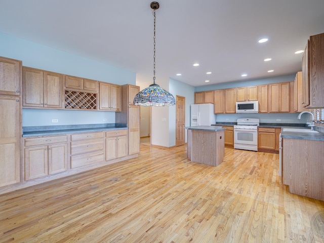 kitchen featuring sink, white appliances, light hardwood / wood-style floors, a kitchen island, and decorative light fixtures