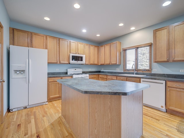 kitchen with white appliances, light hardwood / wood-style floors, sink, and a kitchen island