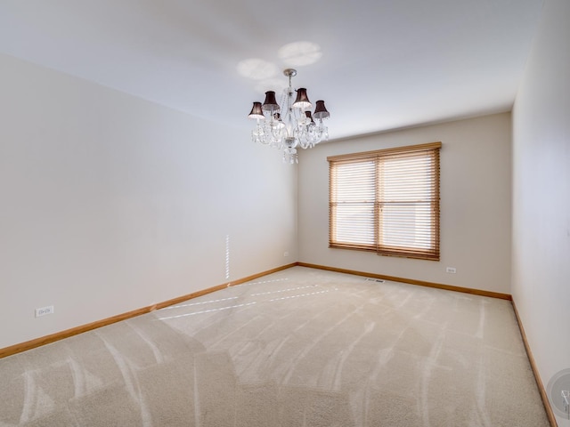 empty room with an inviting chandelier and light colored carpet