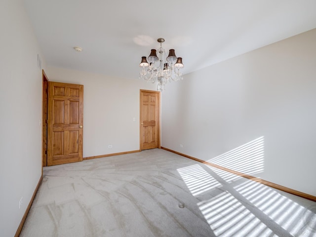 carpeted empty room featuring a notable chandelier