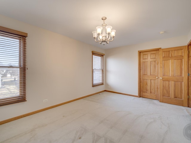 unfurnished bedroom with carpet flooring and a chandelier