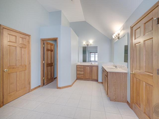 bathroom with tile patterned flooring, vaulted ceiling, and vanity