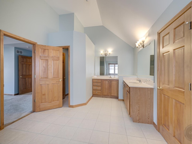 bathroom featuring vanity, tile patterned flooring, and vaulted ceiling