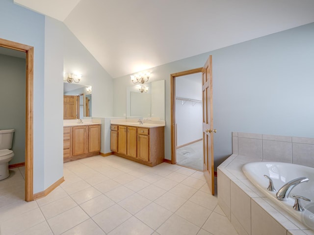 bathroom with lofted ceiling, tile patterned flooring, vanity, tiled bath, and toilet