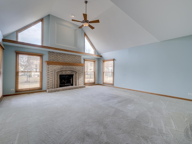 unfurnished living room featuring carpet floors, a brick fireplace, plenty of natural light, and high vaulted ceiling