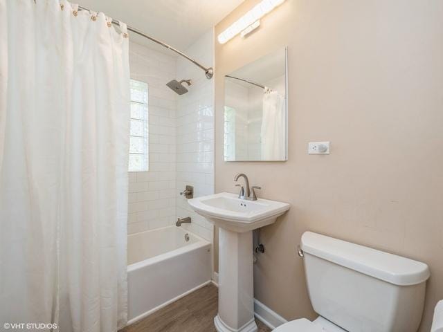 full bathroom featuring a sink, toilet, shower / tub combo, and wood finished floors