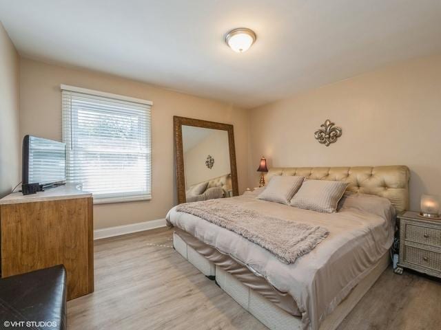 bedroom featuring baseboards and light wood finished floors