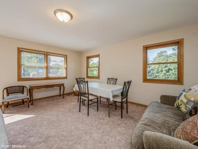 dining space with light carpet and baseboards