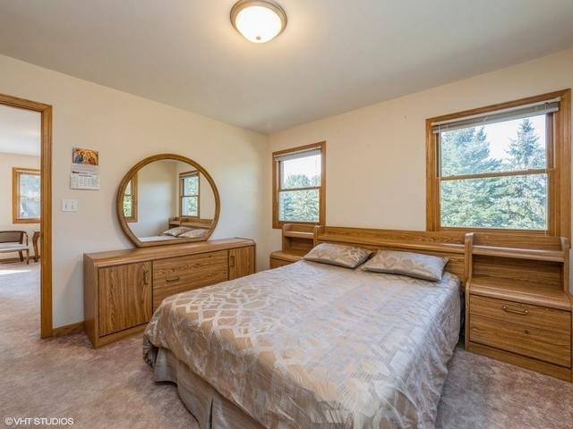 bedroom featuring light colored carpet and baseboards