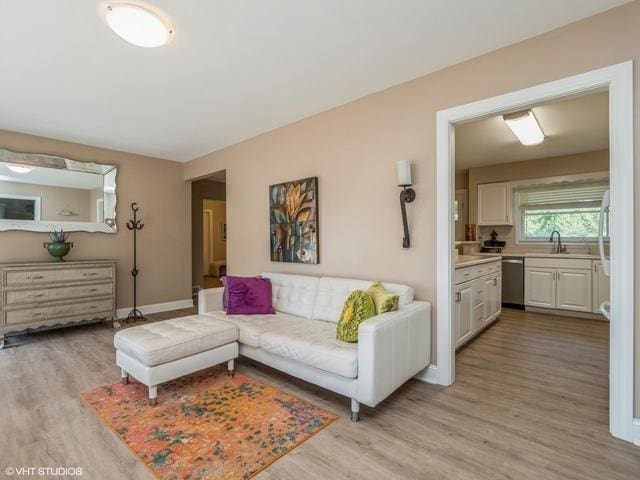 living area with light wood-type flooring and baseboards