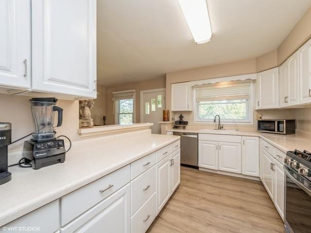 kitchen featuring white cabinets, appliances with stainless steel finishes, and a sink