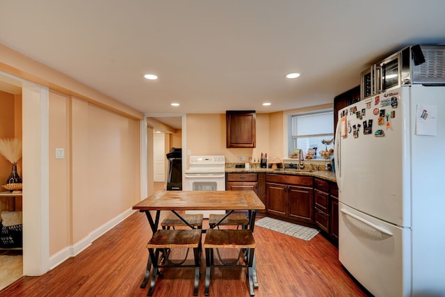 4820 W George St, Chicago, IL 60641 - kitchen with recessed lighting, a sink, light wood-style floors, and white appliances