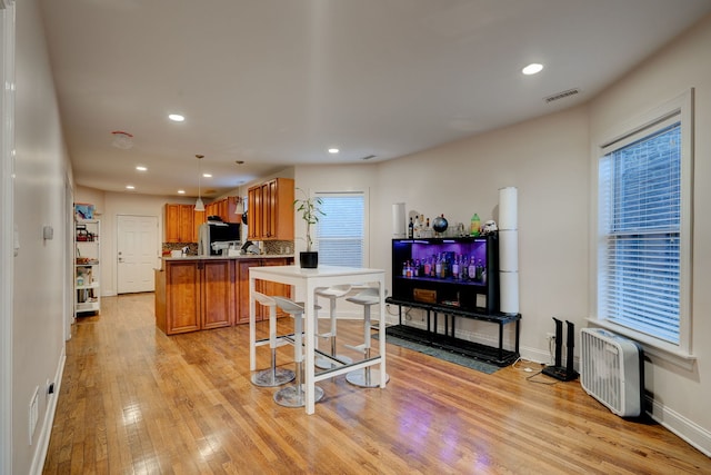 4820 W George St, Chicago, IL 60641 - kitchen with refrigerator, baseboards, visible vents, light wood-style flooring, and brown cabinetry