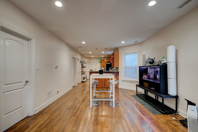 4820 W George St, Chicago, IL 60641 - kitchen featuring light countertops, light wood-style flooring, visible vents, recessed lighting, and a breakfast bar area