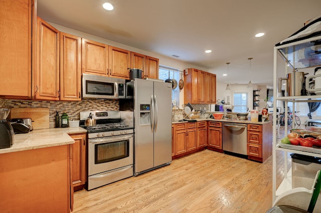 4820 W George St, Chicago, IL 60641 - kitchen featuring decorative backsplash, light wood-style flooring, a healthy amount of sunlight, and appliances with stainless steel finishes
