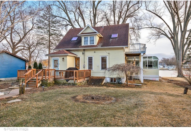 rear view of house with a wooden deck, a yard, and a sunroom