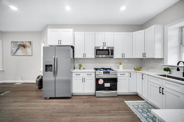 kitchen with white cabinetry, stainless steel appliances, and sink