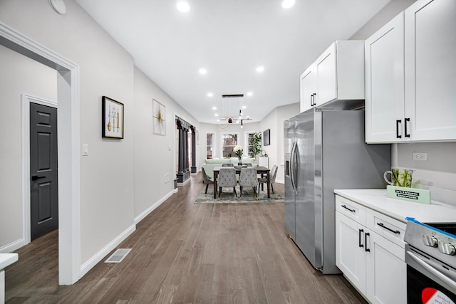 kitchen featuring an inviting chandelier, appliances with stainless steel finishes, wood-type flooring, and white cabinets