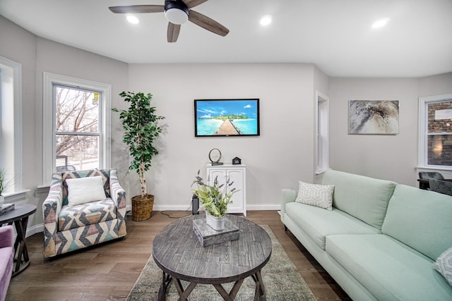 living room featuring ceiling fan and dark hardwood / wood-style flooring