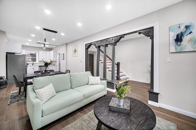 living room with dark hardwood / wood-style flooring and sink