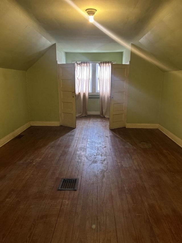 bonus room featuring dark wood-type flooring and vaulted ceiling