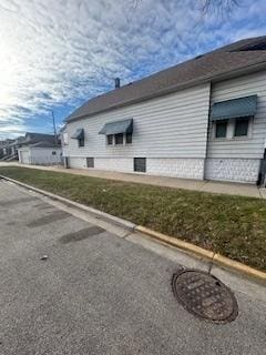 view of side of home with a yard