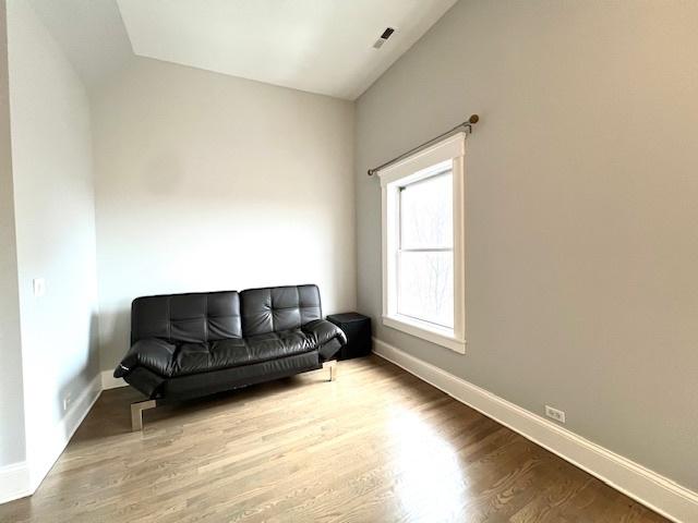 sitting room featuring hardwood / wood-style flooring and vaulted ceiling