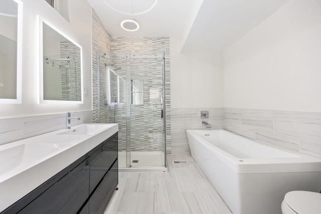 full bathroom featuring vanity, toilet, separate shower and tub, and tile walls